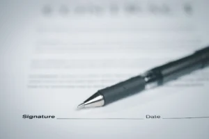 Document with a blank signature line and a black pen.