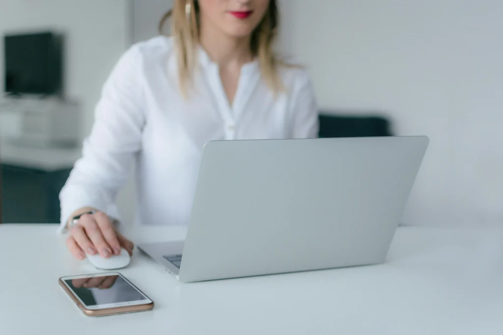 Person interacting with a laptop while seated at a desk.