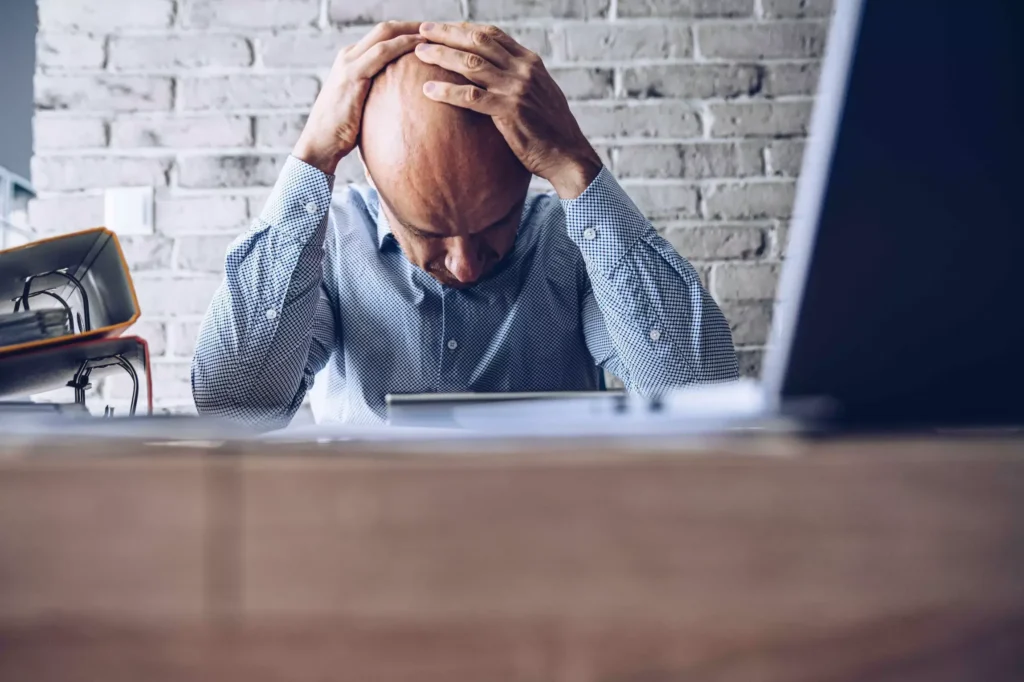 A stressed man sitting at the desk.