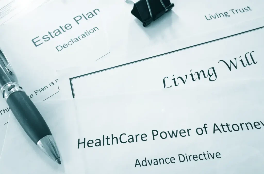 Estate planning documents including a Living Will and HealthCare Power of Attorney, with a pen and binder clip.