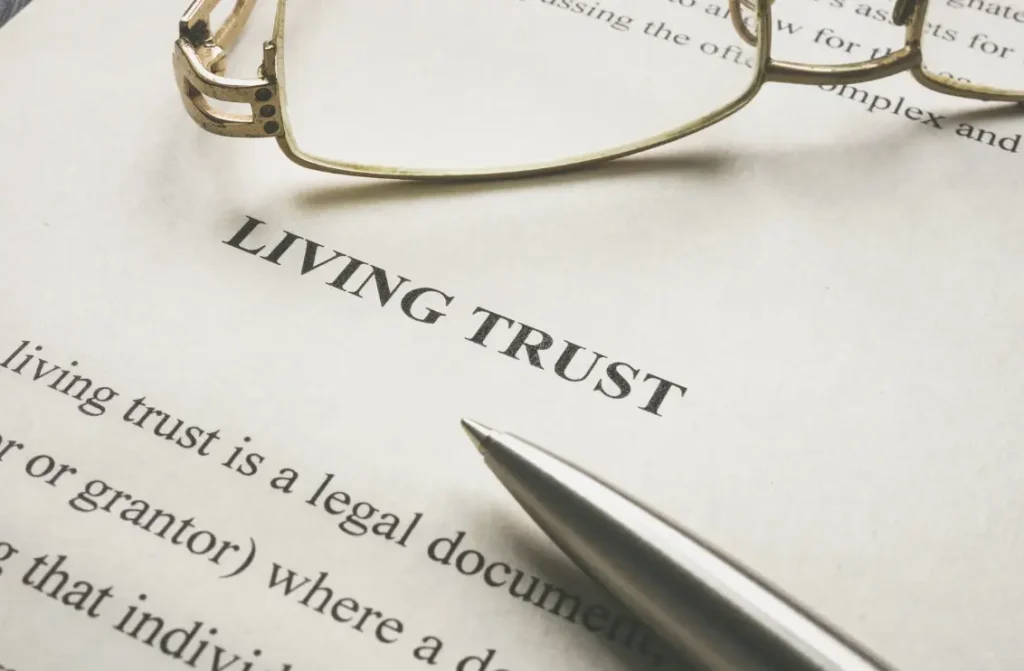 Close-up of a Living Trust document with reading glasses and a pen.